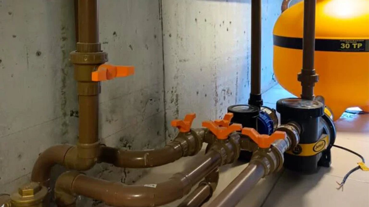Bomba e conjunto de filtragem instalados na casa de máquinas de uma piscina