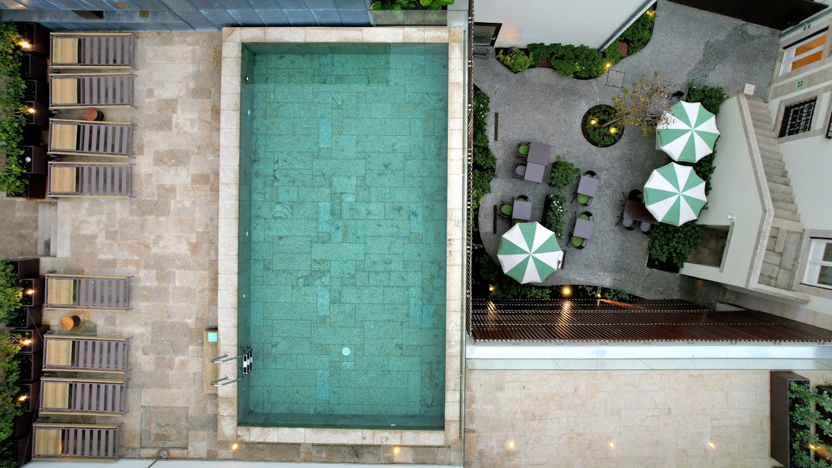 Vista aérea de piscina retangular em área comercial com espreguiçadeiras