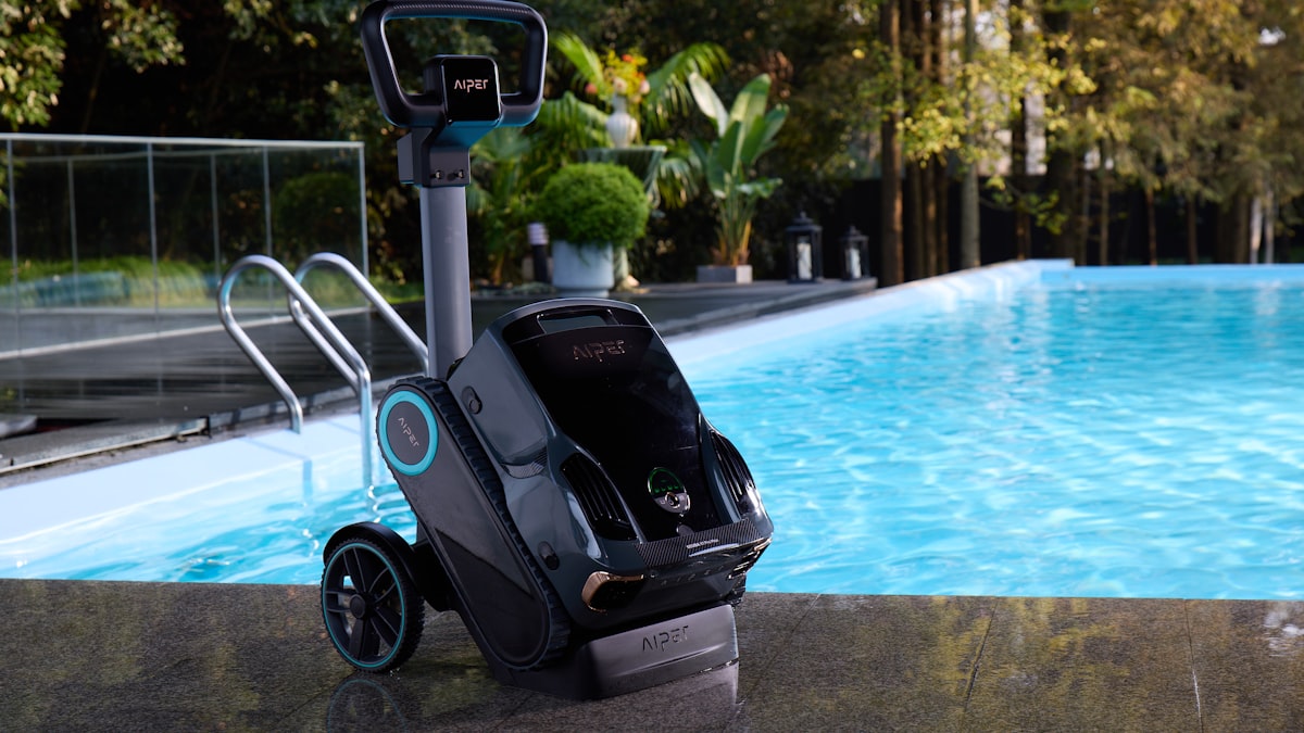 Robô aspirador de piscina ao lado da borda, pronto para limpeza automática
